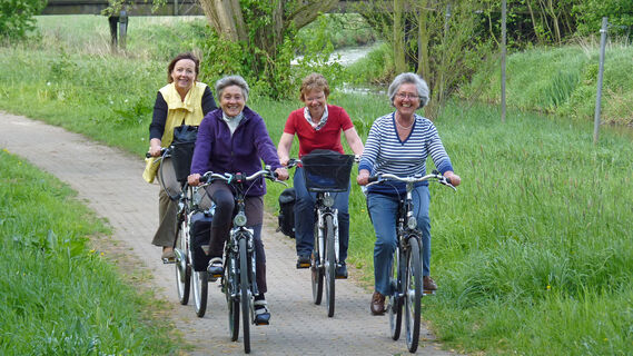 Vier Frauen auf einem gepflasterten Radweg