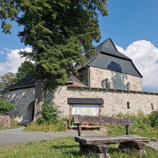 Wehrkirche Triebel mit Sitzgruppe und Informationstafel für Wanderer
