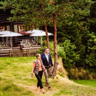Ein Paar steht vor der Blockhütte in Tonbach