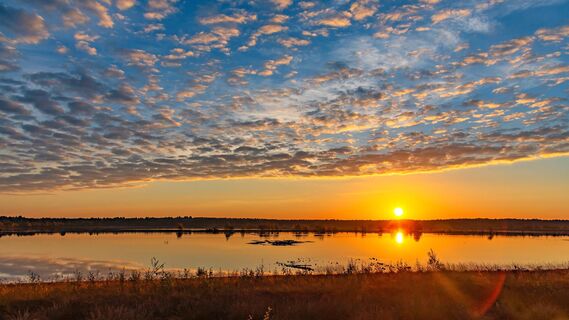 Sonnenaufgang über den Wasserflächen des Tister Bauernmoores