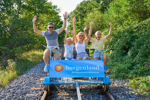 Eine Familie hat Spaß beim Draisinenfahren