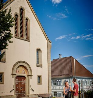 Wanderer vor der St. Ulrich-Kirche in Güttingen