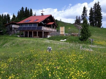 Scheibenhütte mit Gipfelkreuz im Hintergrund