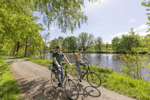Radfahrer auf dem Aller-Radweg am Wasser