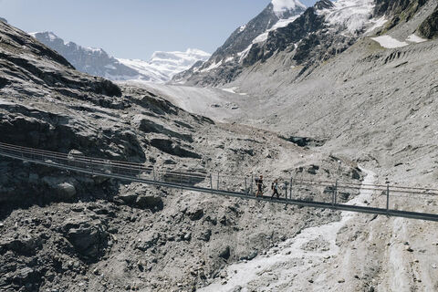 Wanderer auf der Hängebrücke von Corbassière mit dem Grand Combin im Hintergrund
