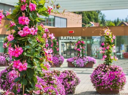 Das moderne Lannacher Rathaus mit sommerlicher Blumenpracht am Hauptplatz