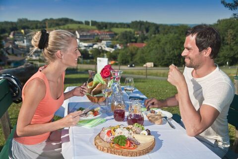 Paar bei der Jause mit Blick auf die Thermenhotels