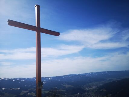 Das Gipfelkreuz auf der Großen Scheibe mit herrlichem Blick auf das Mürztal.