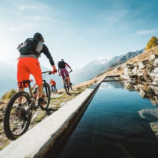 Mountainbiker fahren beim Abstieg nach Giw in der Nähe eines Pools.