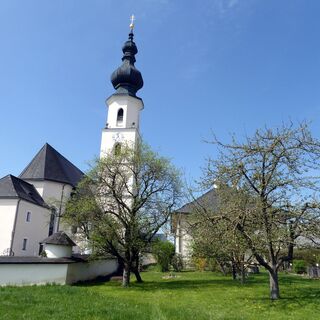 Die Pfarrkirche von Köstendorf mit dem Pfarrgarten, der von Carl Zuckmayer besonders erwähnt wurde.