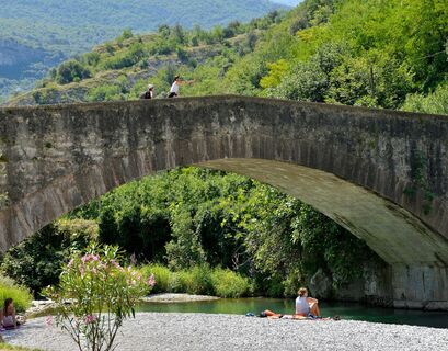 Die Römische Brücke in Ceniga mit dem kleinen Strand am Fluss