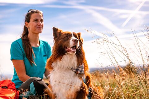 Frau mit Hund blicken in die Ferne