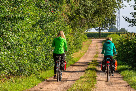 Zwei Radfahrerinnen auf einem ländlichen Weg