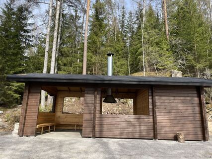 Holzkonstruktion eines Wanderunterstands, im Hintergrund Bäume